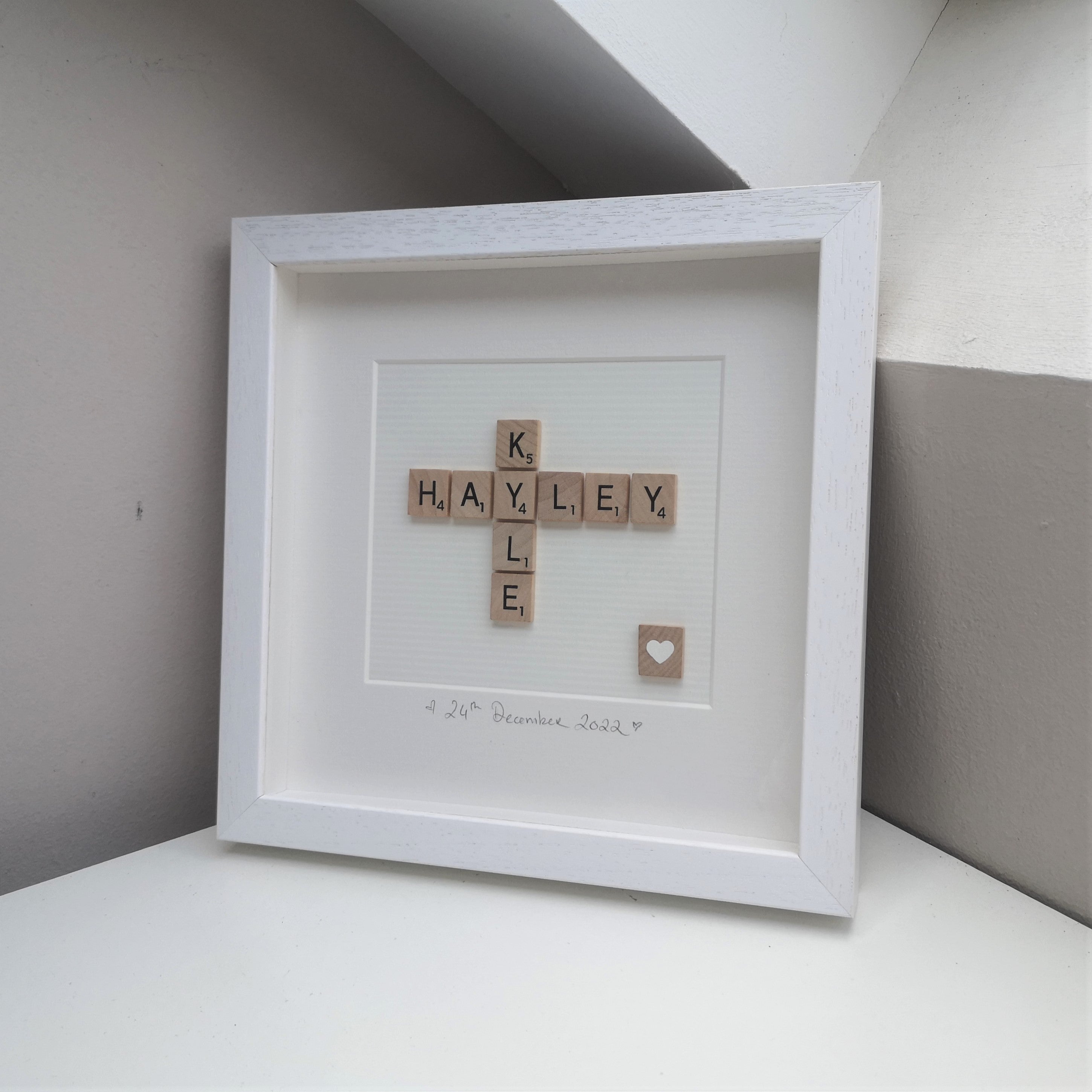 Personalised Engagement Scrabble name frame with 2 names on white backing and white loveheart tile