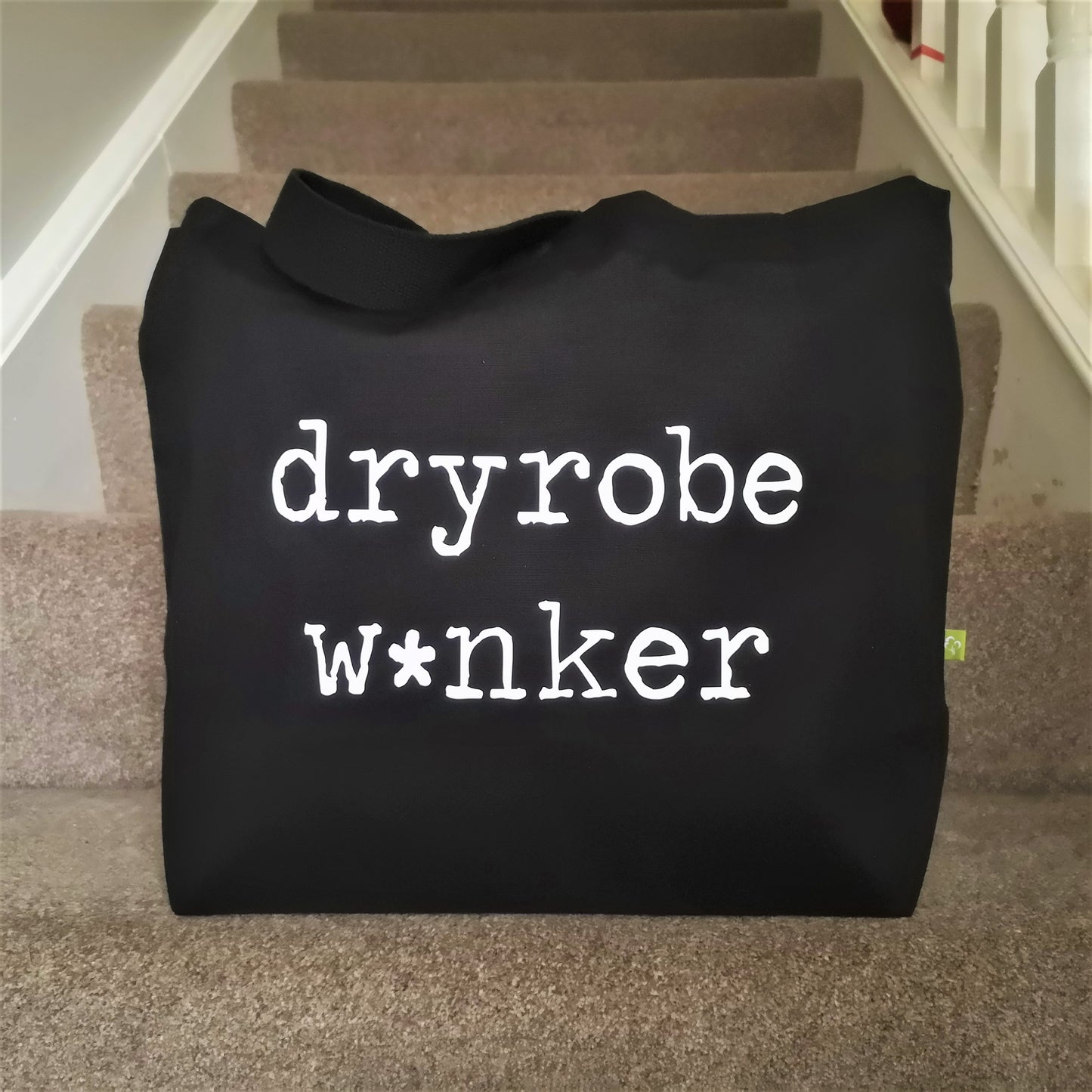 A black organic tote with the following written on it in white type font - DRYROBE W*NKER