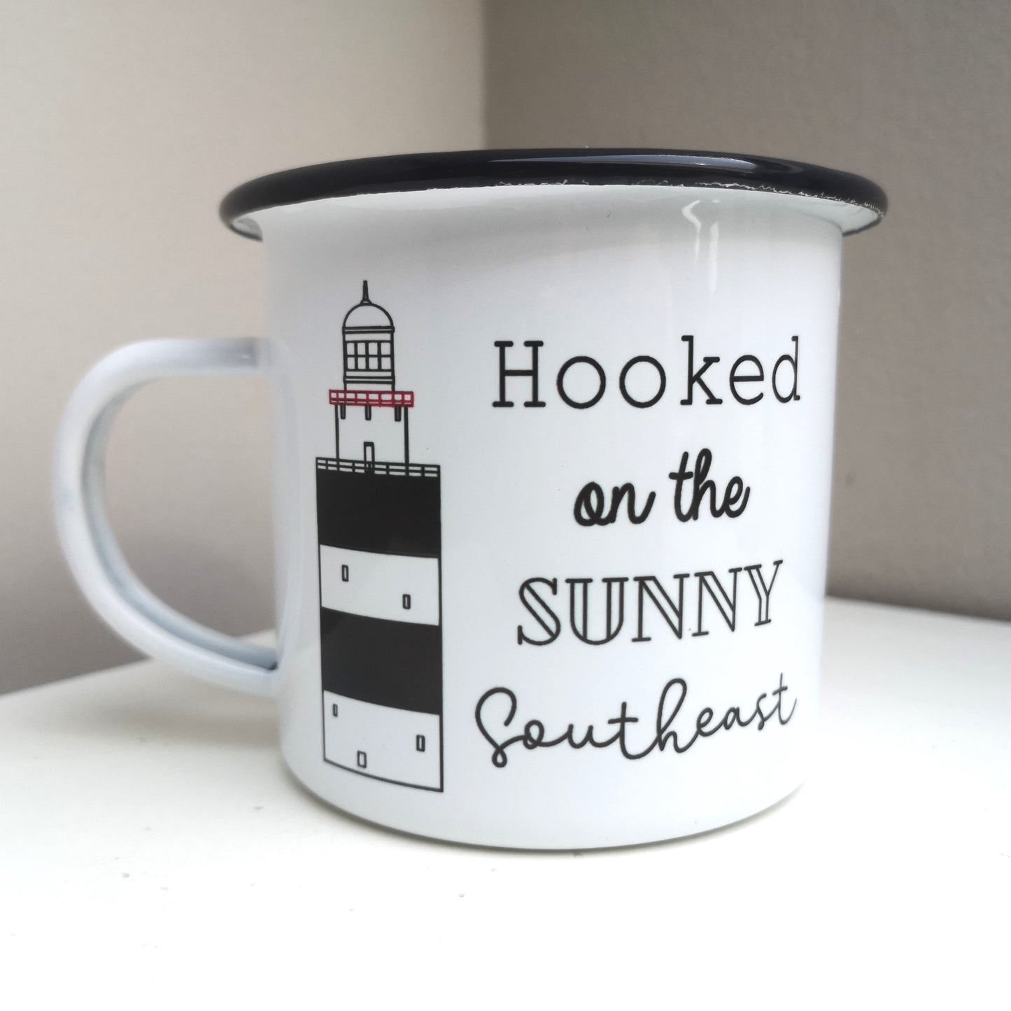 Another view of the Hooked on the Sunny Southeast enamel mug, with a drawing of the infamous Hook Head lighthouse on it