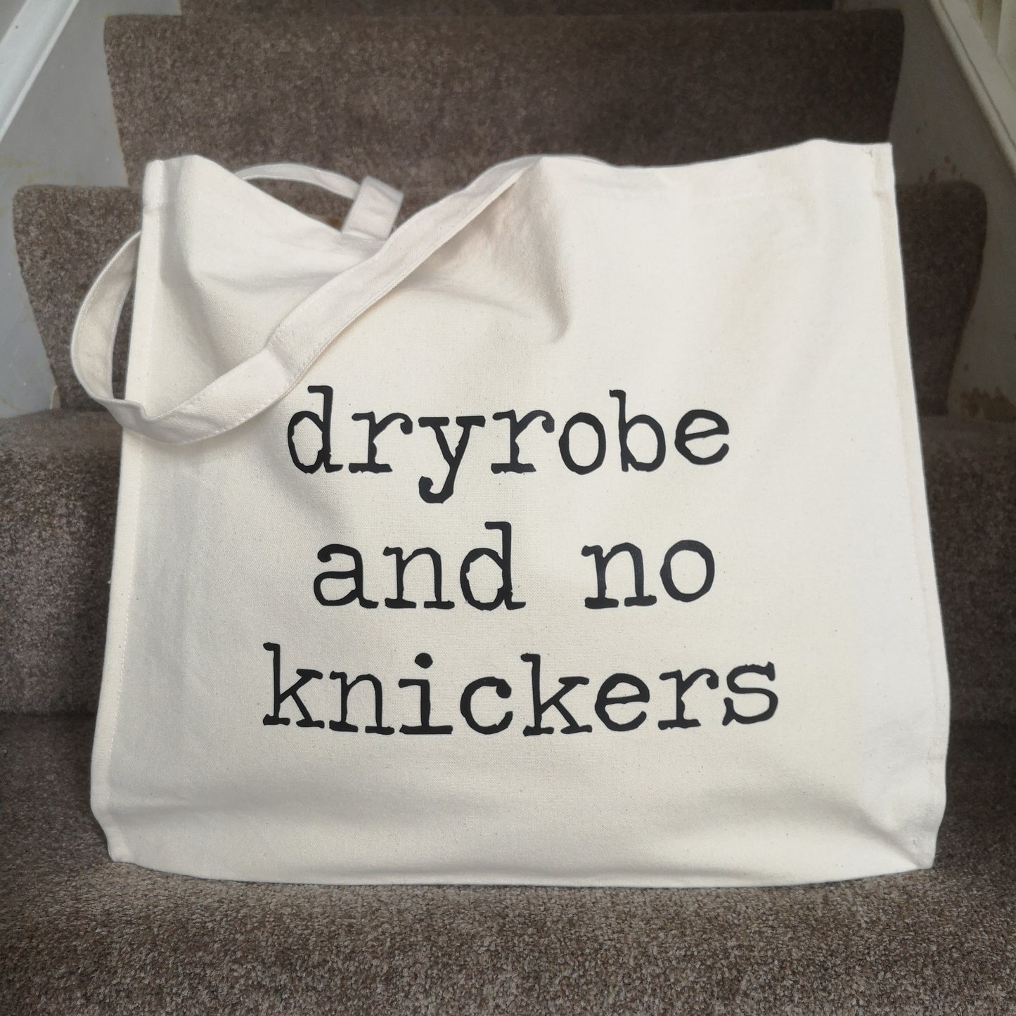 A natural cream organic cotton tote with toggle closing, with the following slogan written in type font on the front - Dryobe and no knickers