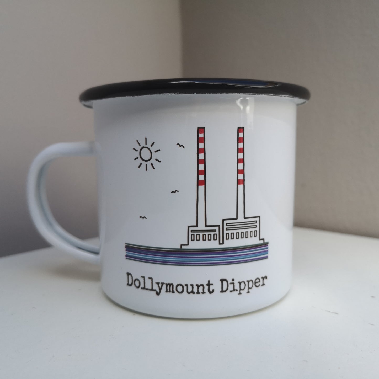 A white steel enamel mug with the poolbeg towers on it, with DOLLYMOUNT DIPPER written in type font below