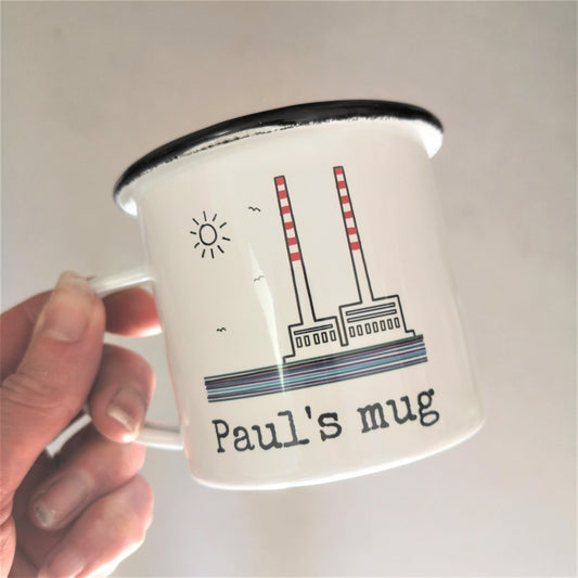 A personalised white steel enamel mug with a hand drawn picture of the Poolbeg towers on it