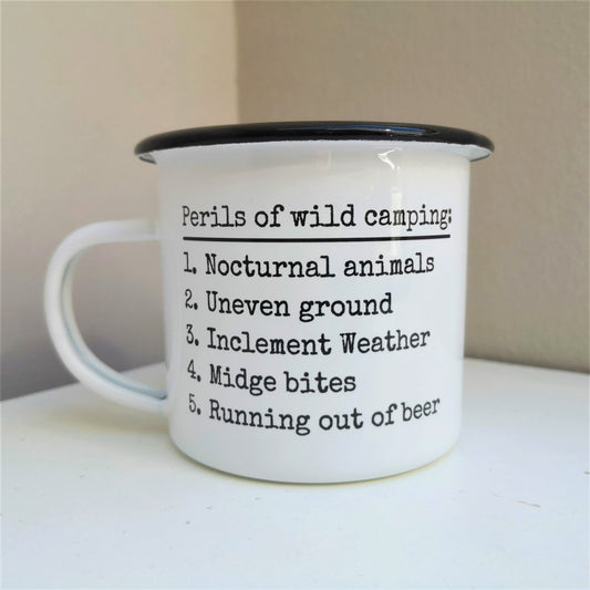 A White enamel mug with a black rim with the following on the front -Perils of wild camping: Nocturnal Animals, Uneven ground, Inclement weather, midget bits, Running out of beer