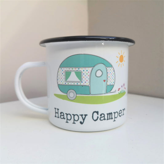 A white steel enamel mug with a cartoon picture of a caravan in pretty pastel colours, and below it written in type font is HAPPY CAMPER