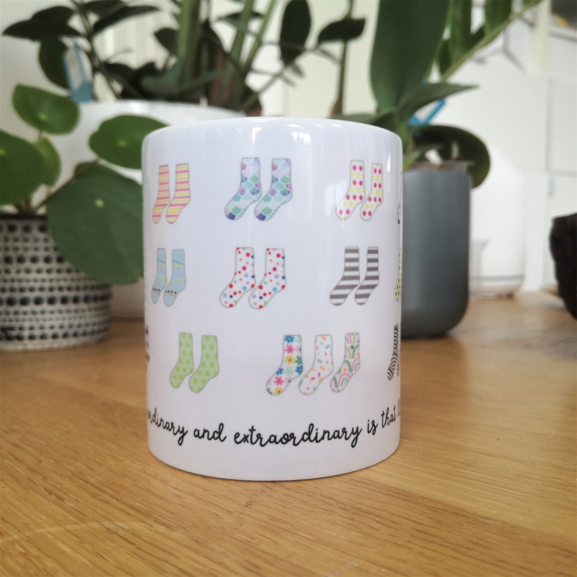 A mug that celebrates Down Syndrome and how it is the result of having 47 chromosomes instead of 46.  Each colourful pair of socks represents the 44 chromosomes we all have, but pair 21 has 3 socks instead of 2.