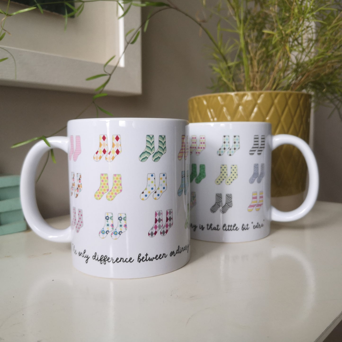 A mug that celebrates Down Syndrome and how it is the result of having 47 chromosomes instead of 46.  Each colourful pair of socks represents the 44 chromosomes we all have, but pair 21 has 3 socks instead of 2.