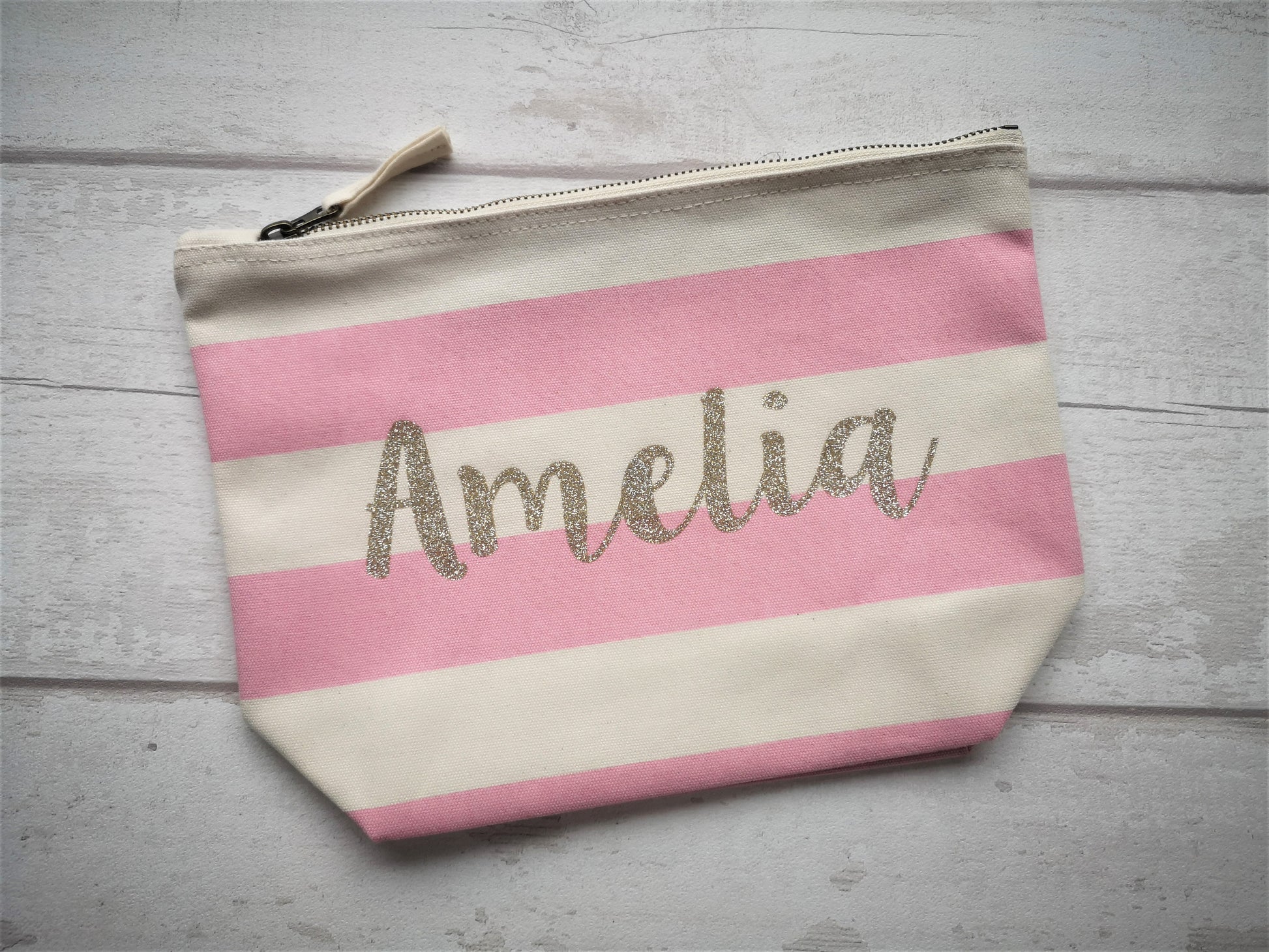A Pink and White personalised pouch with the name in gold glitter textured font