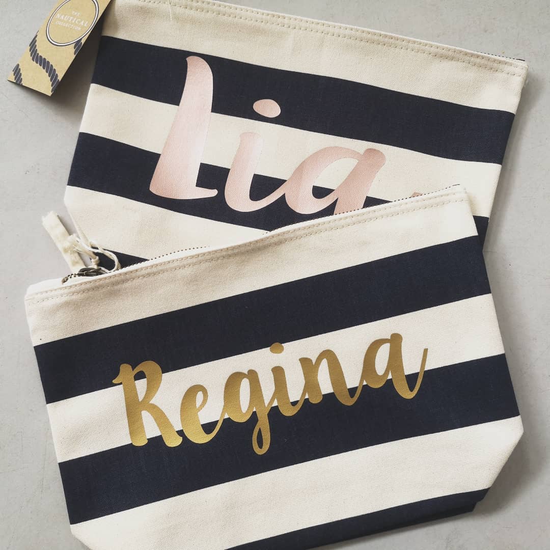 2 Navy and White personalised pouches with the names in gold textured font and rose gold textured font