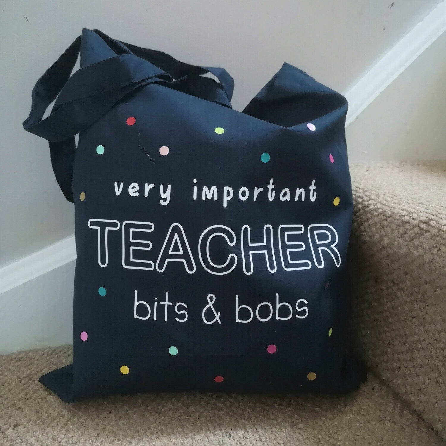A personalised lightweight black cotton tote with VERY IMPORTANT TEACHER BITS & BOBS on it. The text is surrounded with multicoloured polkadots